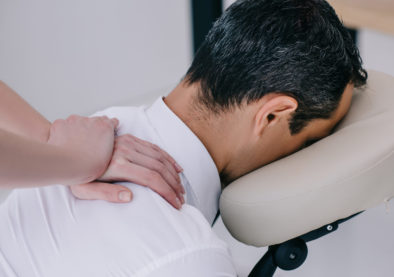 close-up shot of professional masseuse doing seated massage for businessman