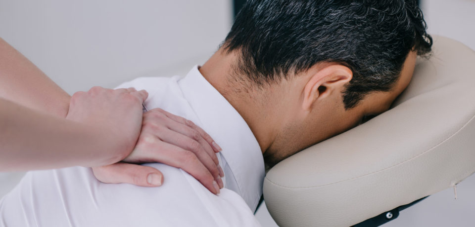 close-up shot of professional masseuse doing seated massage for businessman