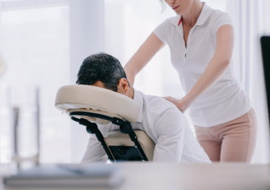 masseuse doing seated massage for businessman
